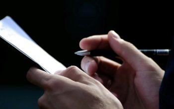 close-up of hands holding pen and clipboard