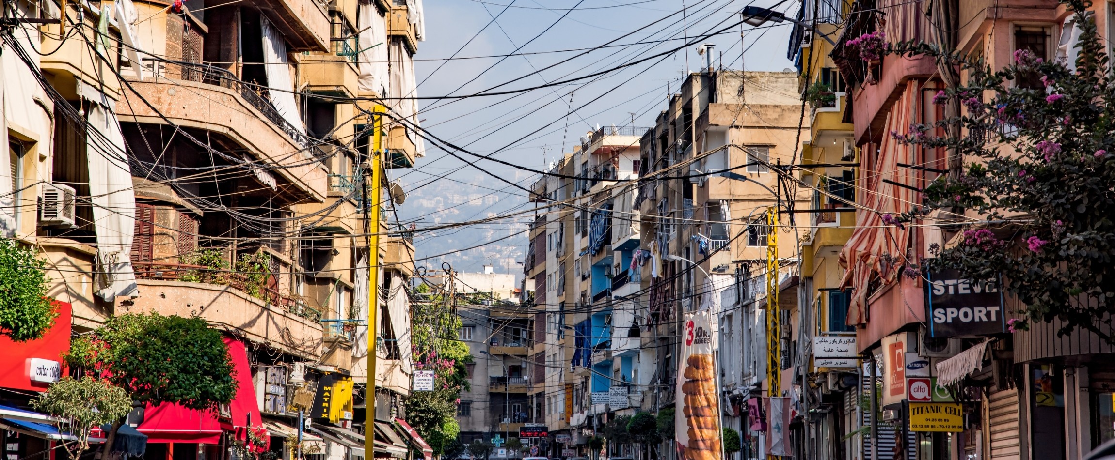 cables hanging between colourful buildings Beirut Lebanon