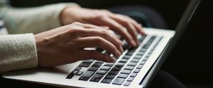 hands typing on laptop