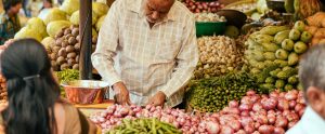 man cutting vegetables outdoor food stall India