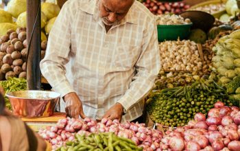 man cutting vegetables outdoor food stall India