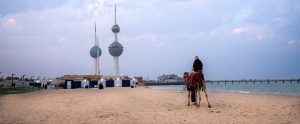 person riding camel on sandy beach Kuwait City Kuwait