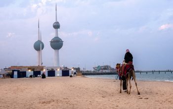 person riding camel on sandy beach Kuwait City Kuwait