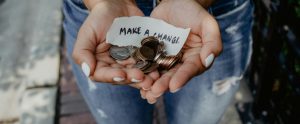 hands holding coins and make a change sign
