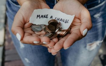 hands holding coins and make a change sign