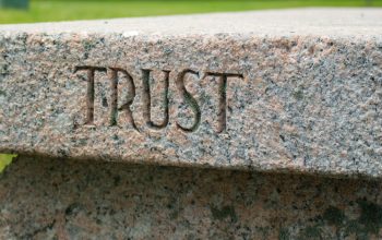 stone bench with word trust carved into side