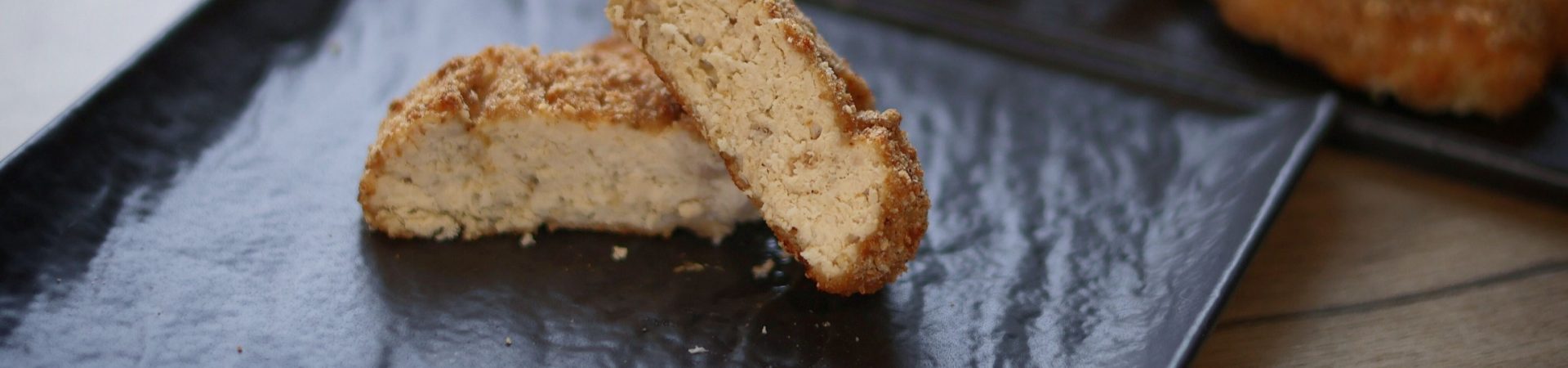 close-up of breaded vegan chicken nugget on black plate