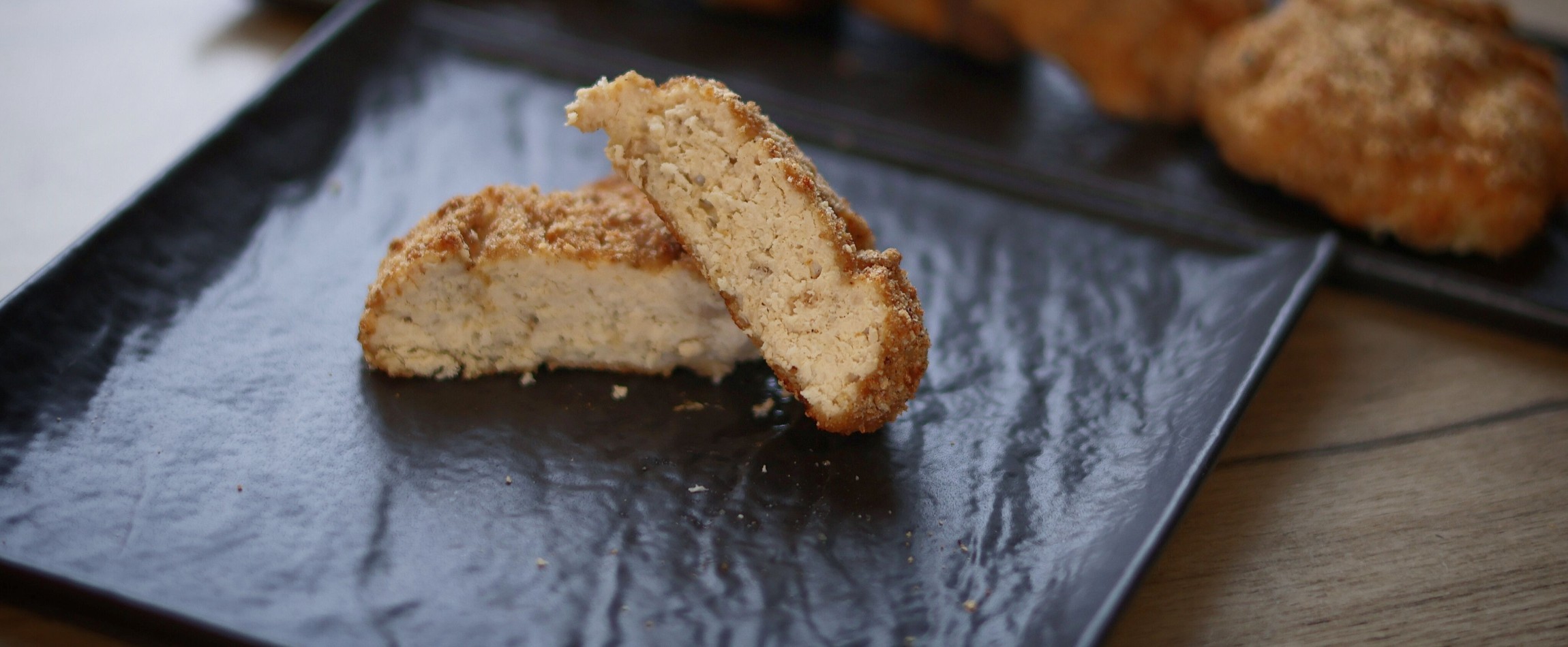 close-up of breaded vegan chicken nugget on black plate